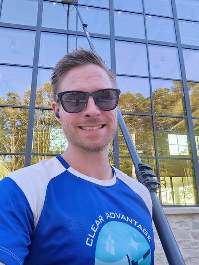 Aaron with water-fed pole on commercial building