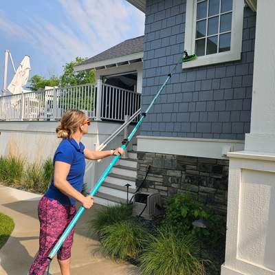 Tina cleaning windows with water-fed pole